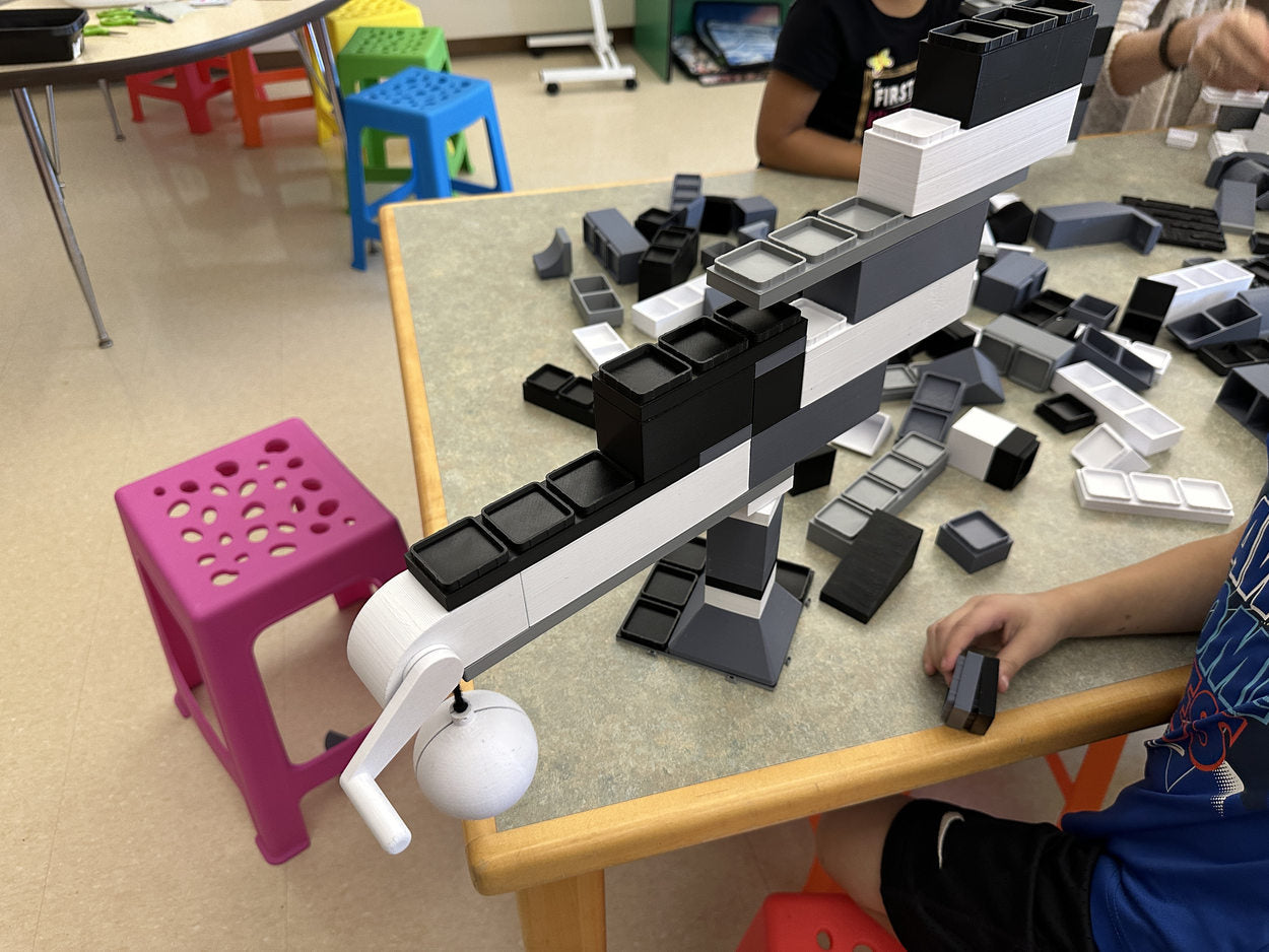 Students collaborating on a large structure at their classroom table