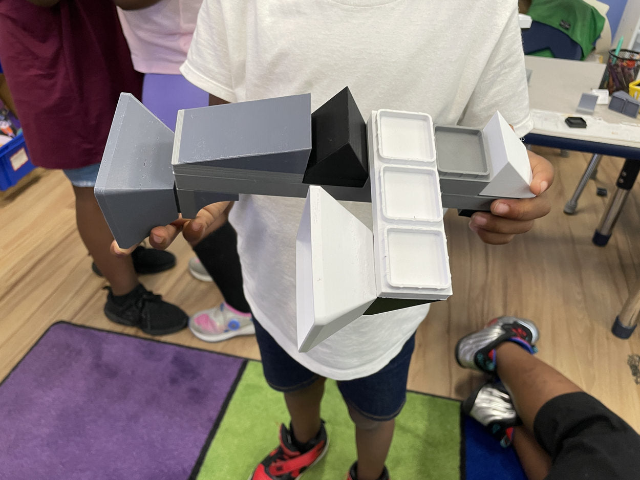 Student holding their original construction during playtesting