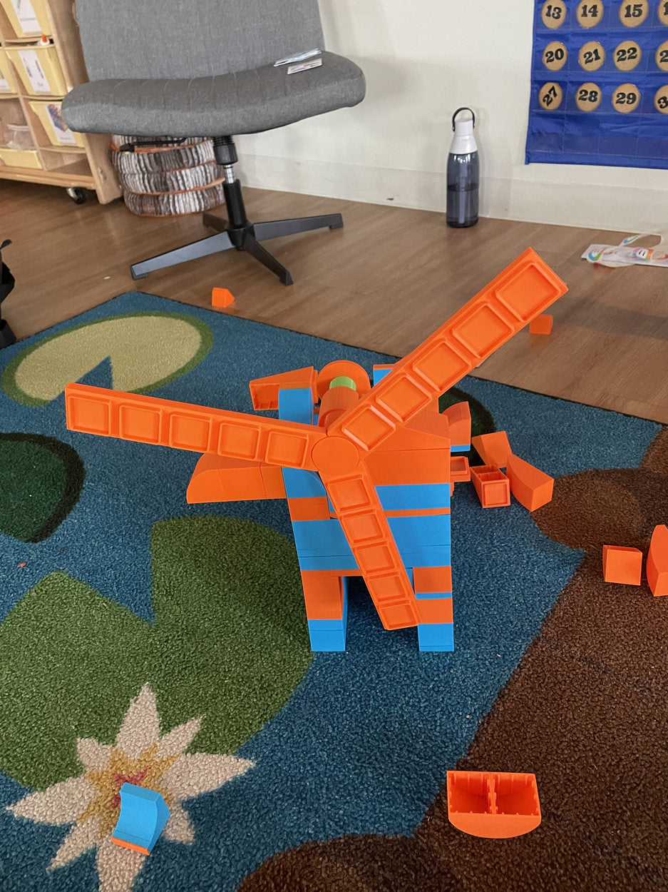 A horizontal orange-and-blue structure on a playroom rug