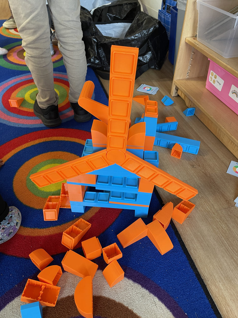 A tall open-ended block construction in a classroom