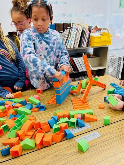 A student exploring mechanical pieces and colorful blocks