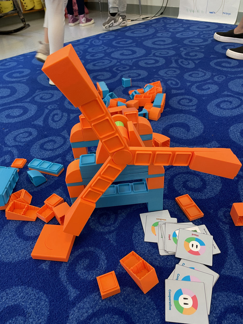 Orange and blue windmill built on a classroom carpet