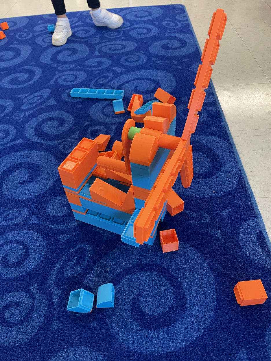 A child-designed upright windmill surrounded by building blocks